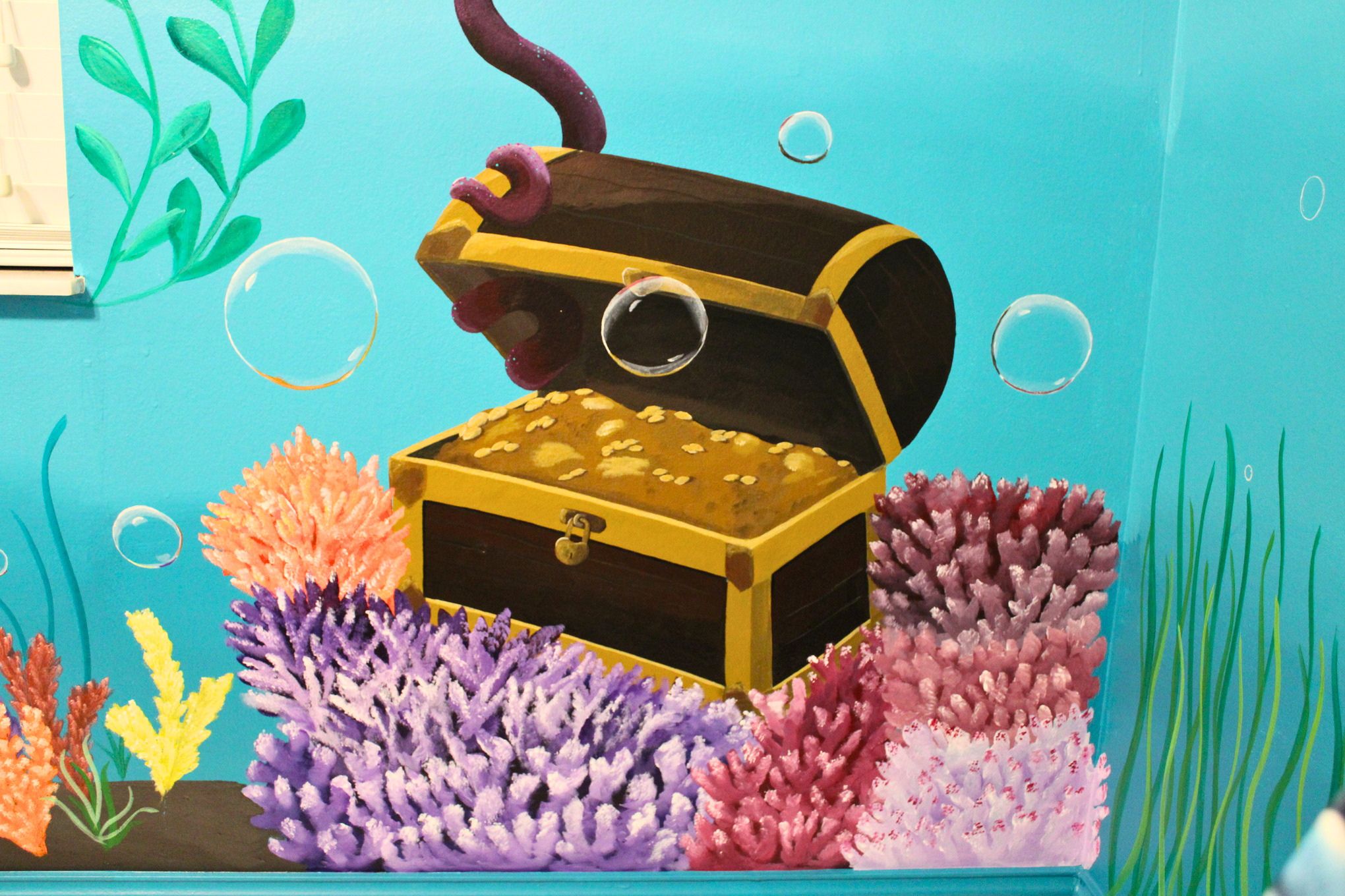Treasure chest nested among branching corals and bubbles